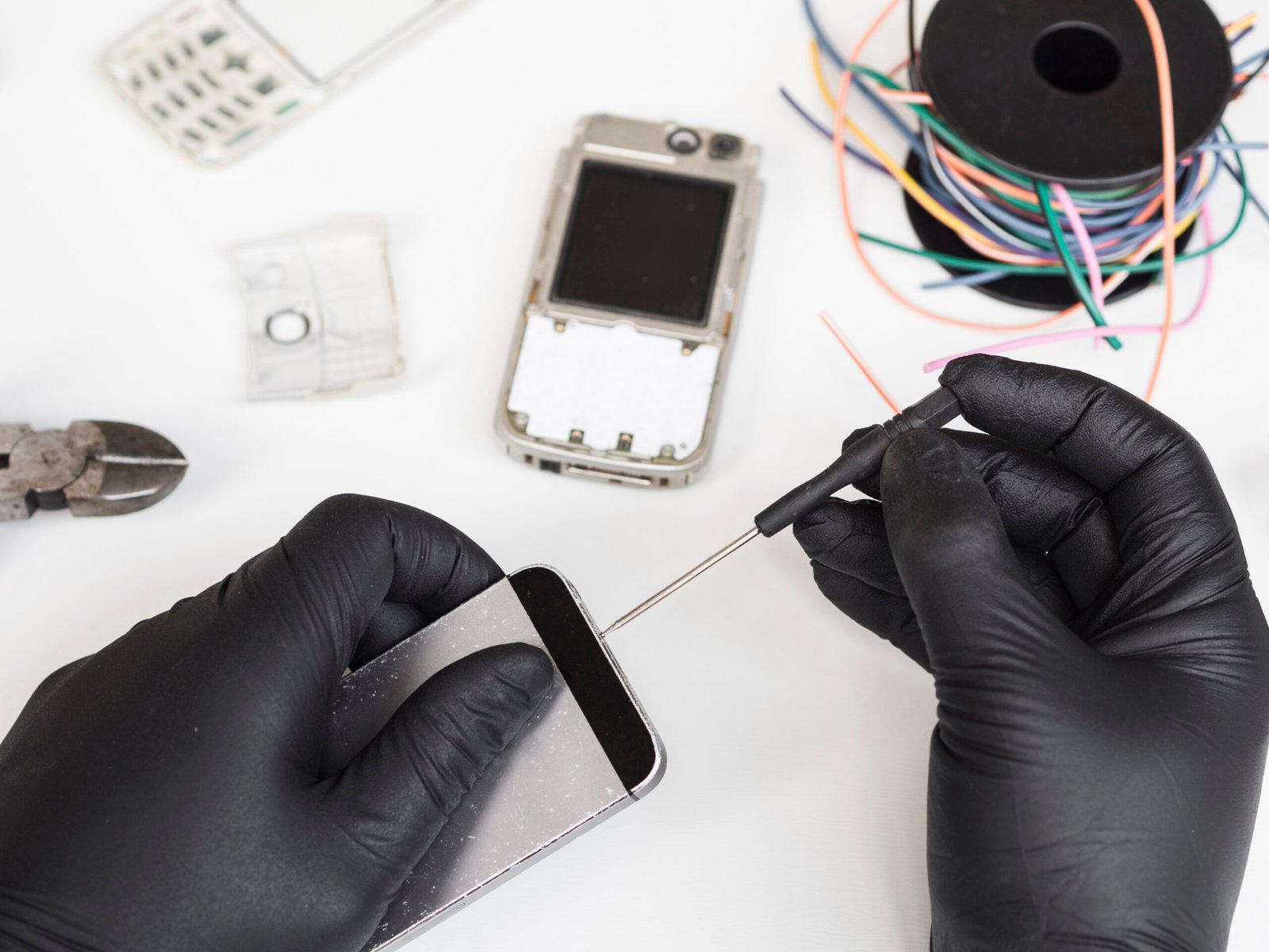 man using screwdriver to open a cell phone